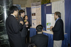 Justin Kovac explaining his research to 4 others.